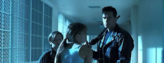 Sarah Connor turning epically, with John Connor and the Good Terminator in the background